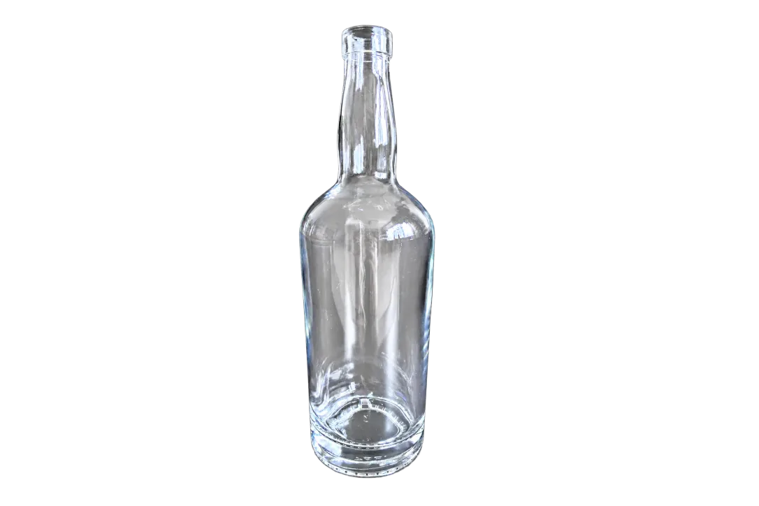 Clear empty glass spirit bottle with a long neck and thick base on a dark background