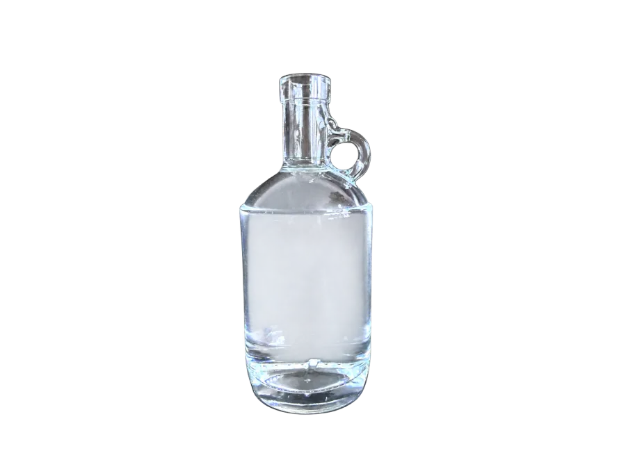 Clear glass liquor bottle with a cylindrical body and integrated side handle on a dark background