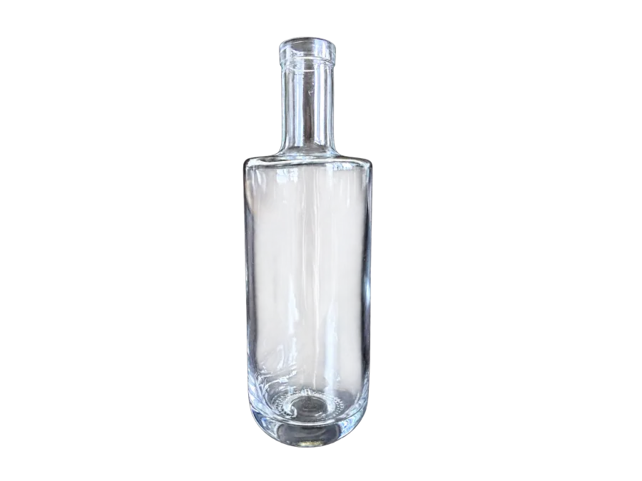 Clear empty cylindrical glass liquor bottle with a long neck and stopper on a dark background