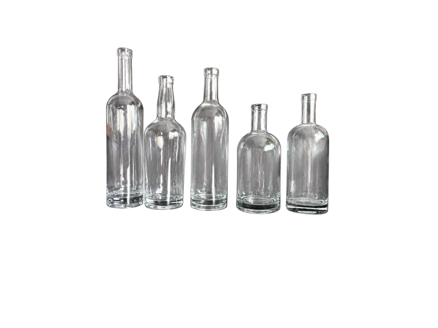 Five empty clear glass bottles with varied rounded body shapes arranged side by side on a dark surface