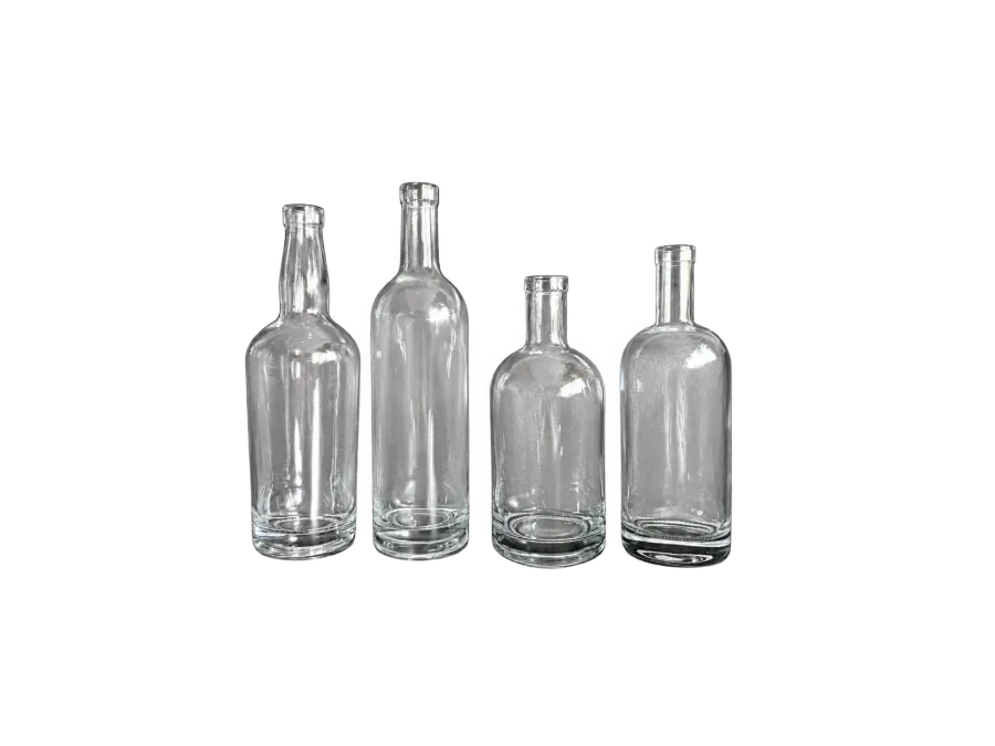 Four empty clear glass bottles with varied body shapes arranged against a dark background