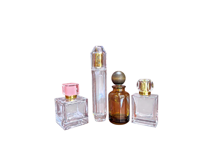 Four decorative glass fragrance bottles with faceted and spherical caps arranged against a red backdrop.
