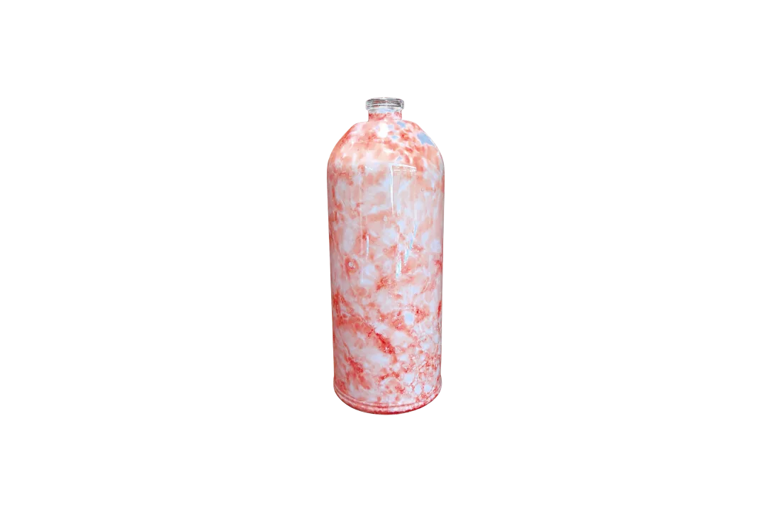Red-and-white marbled bottle standing on a wooden tabletop against a reddish-brown background